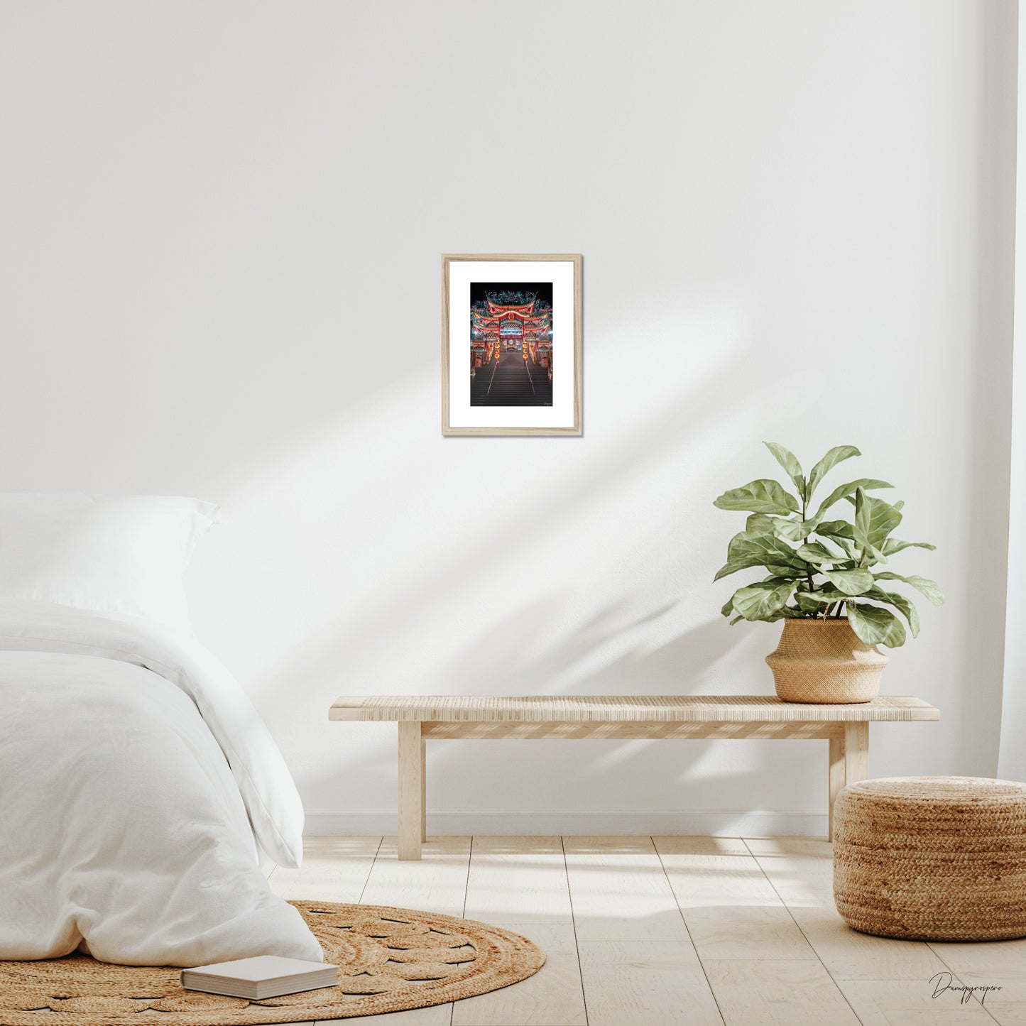 Mockup of wall art showing a small beige wooden frame that is hanging on the wall of a bedroom and contains a photo of a very impressive Taoist temple during the night in Taipei Taiwan