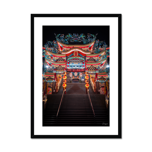Framed art in a black wooden frame showing a very impressive Taoist temple with lights that are glowing in the night in Taipei Taiwan