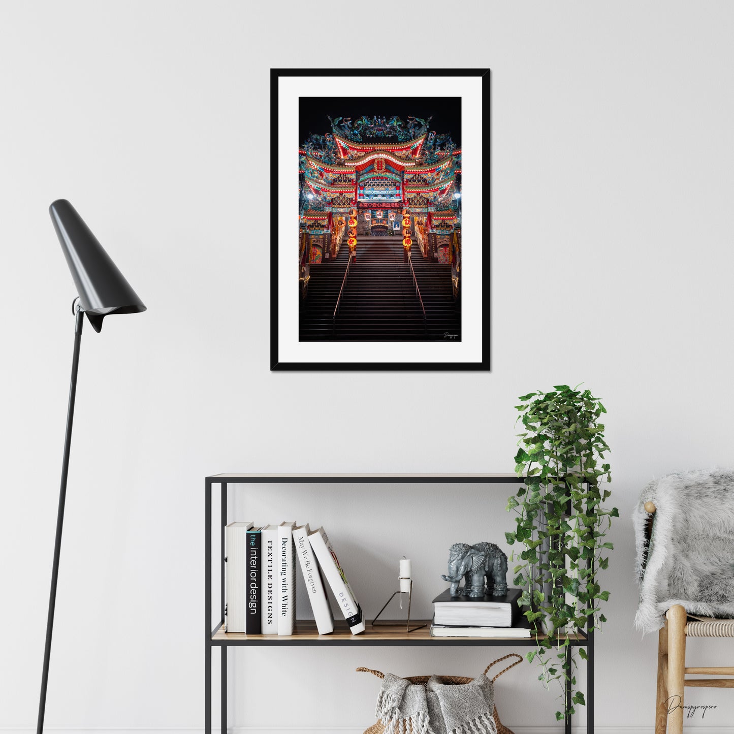 Mockup of wall art showing a big black wooden frame that is hanging on the wall of a living room and contains a photo of a very impressive Taoist temple during the night in Taipei Taiwan