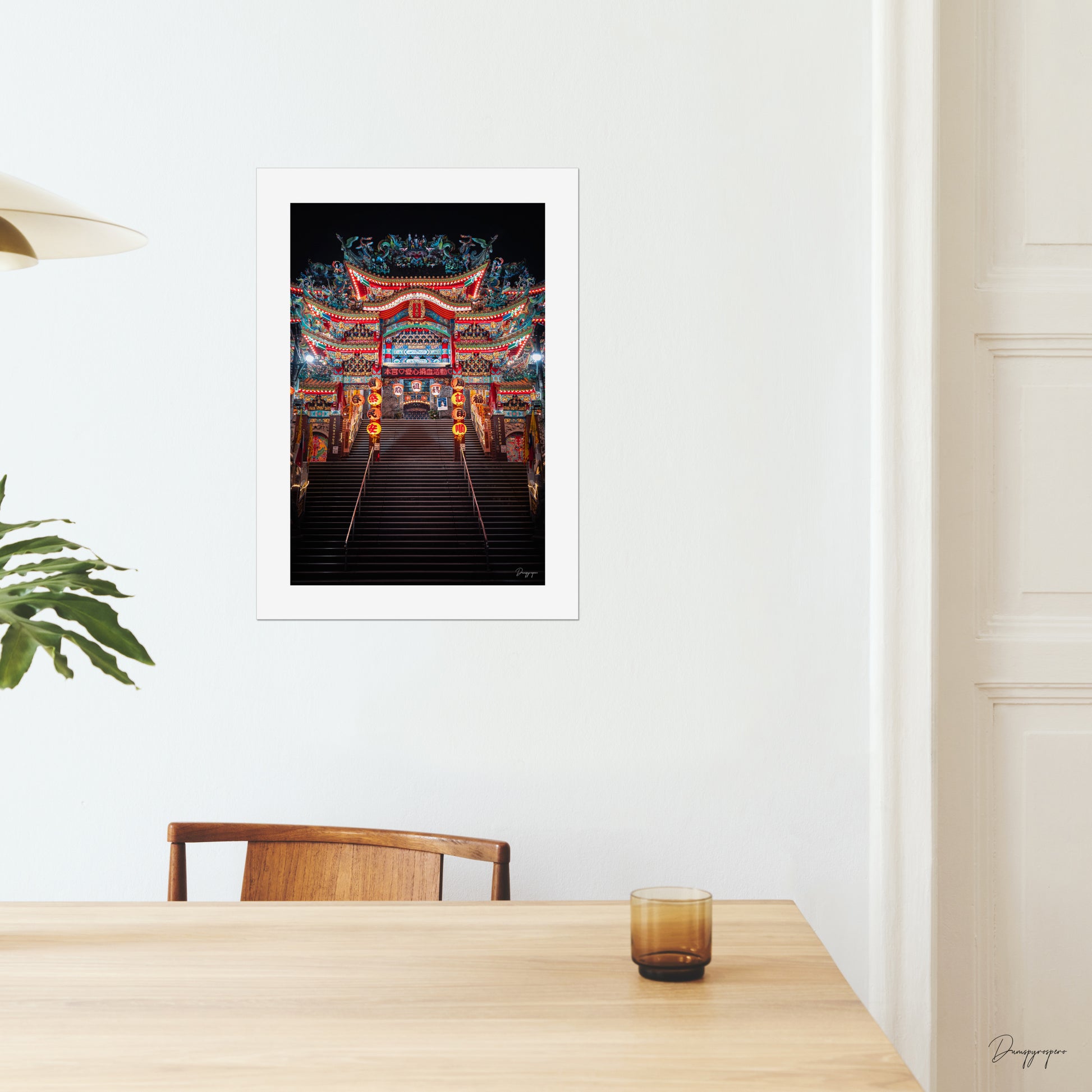 A mockup of a big poster on the wall of a dining room showing a very impressive Taoist temple with lights that are glowing in the night in Taipei Taiwan