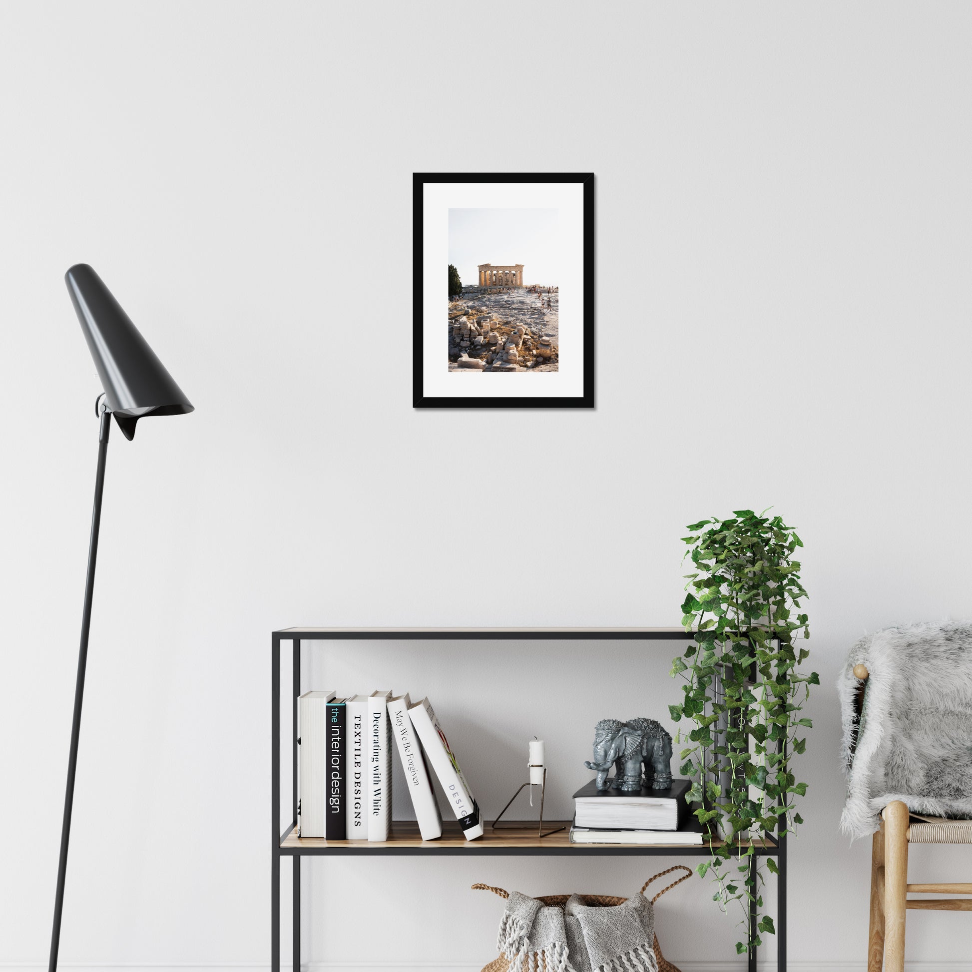 Mockup of wall art showing a small black wooden frame that is hanging on the wall of a living room and contains a photo of the Parthenon on the hill of Acropolis in Athens Greece